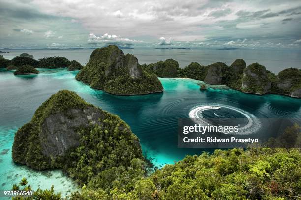 turquoise lagoon among rocks under cloudy sky, wayag island, raja ampat, west papua, indonesia - west papua stock pictures, royalty-free photos & images