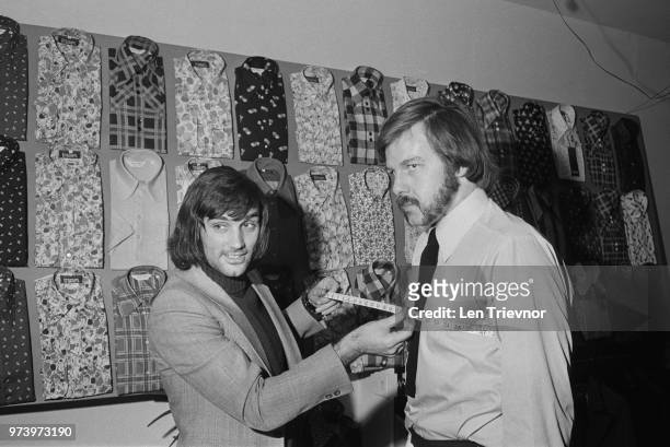 Northern Ireland and Manchester United footballer George Best pictured on left taking the chest measurements of racing driver Mike Taylor at the...