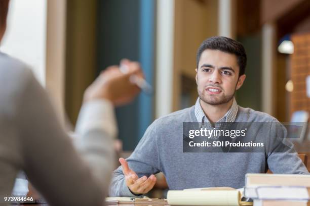 serious students have discussion in library - business conflict stock pictures, royalty-free photos & images