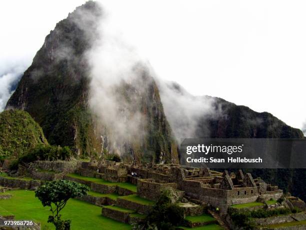 huayna picchu mountain over machu picchu incan ruins in clouds, peru - berg huayna picchu stock-fotos und bilder