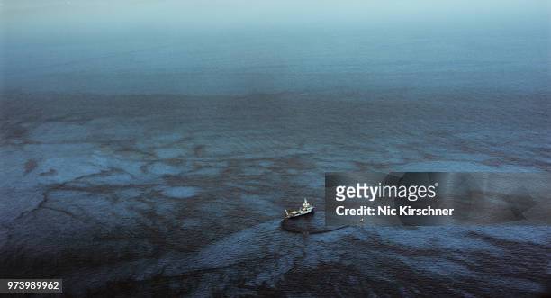 industrial ship in oil spill on sea, gulf of mexico, mississippi, usa - olielek stockfoto's en -beelden