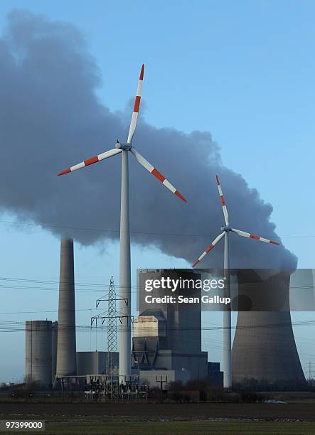 Steam rises from the coal-fired electric power plant Mehrum as wind turbines twirl nearby next to electric power masts on March 3, 2010 in...