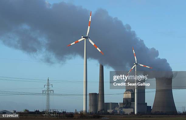 Steam rises from the coal-fired electric power plant Mehrum as wind turbines twirl nearby next to electric power masts on March 3, 2010 in...