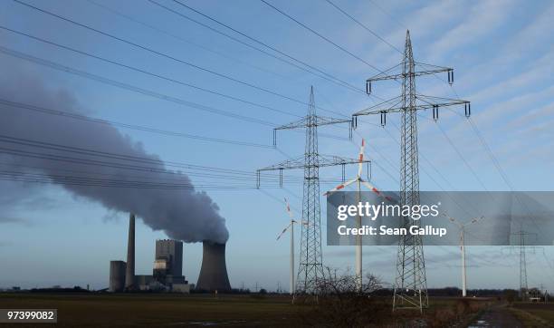 Steam rises from the coal-fired electric power plant Mehrum as wind turbines twirl nearby next to electric power masts on March 3, 2010 in...