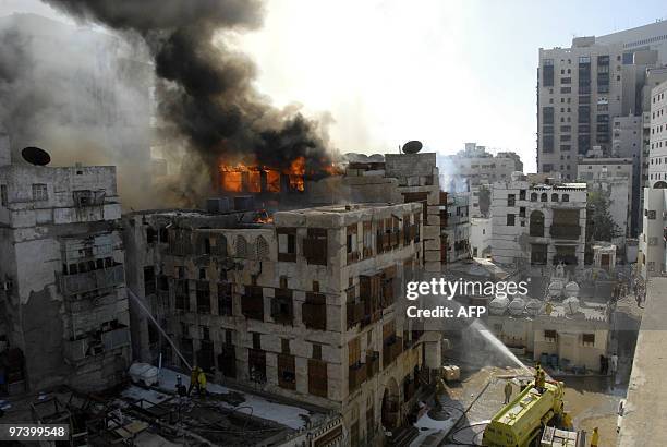 Firefighters douse the flames in one of the buildings which caught fire in the historic quarter of the Saudi Red Sea port city of Jeddah on March 3,...