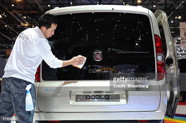 An employee cleans an electric Fiat Doblo automobile is seen on display on the second press day of the Geneva International Motor Show in Geneva,...