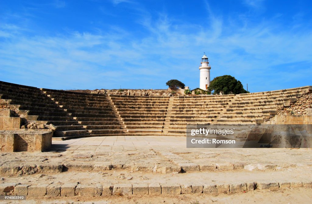 Ancient amphitheater with lighthouse in background, Paphos Archaeological Park, Cyprus