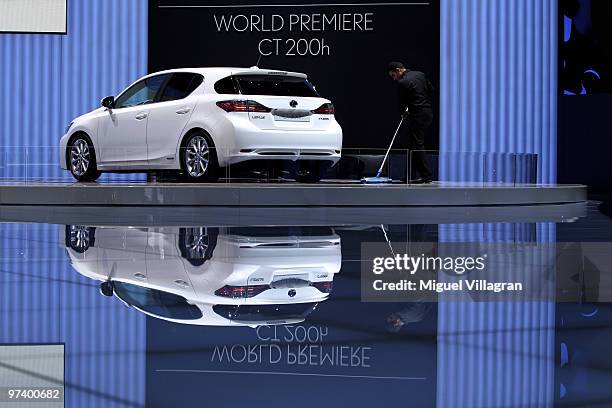 Man cleans the floor next to the Lexus CT 200h during the second press day at the 80th Geneva International Motor Show on March 3, 2010 in Geneva,...