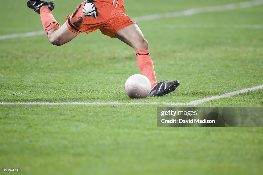 Male soccer goalie kicking ball. 