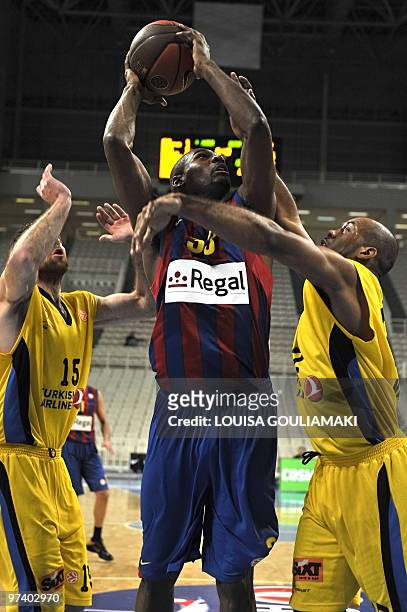 Maroussi BC Lucas Jamon and Kostas Kaimakoglou try to stop Regal Barcelona Pete Mickeal during their Euroleague basketball TOP 16 match at the OAKA...