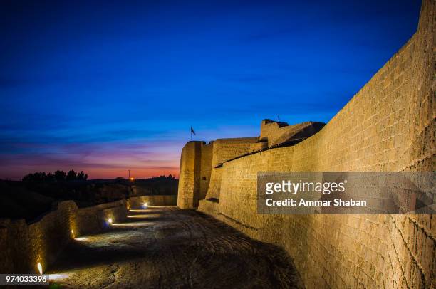 bahrain fort in the blue hour - bahrain tourism stock pictures, royalty-free photos & images