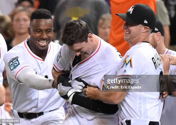 Lewis Brinson and Trevor Richards of the Miami Marlins celebrate with Brian Anderson of the Miami Marlins after he hit the game winning sacrifice fly...