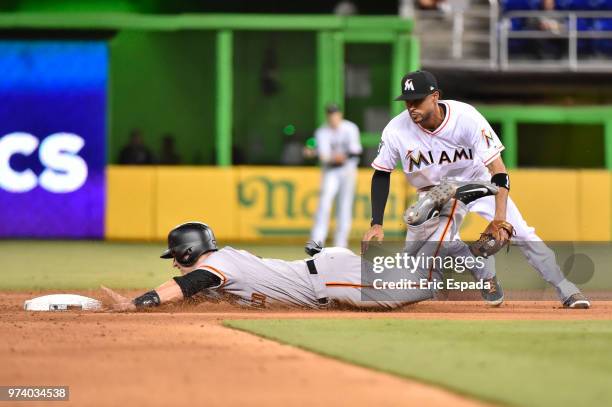 Buster Posey of the San Francisco Giants avoids the tag of Yadiel Rivera of the Miami Marlins as he steals second base in the ninth inning of the...