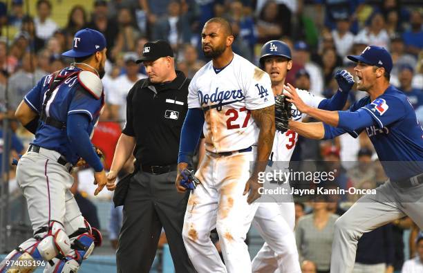Cole Hamels of the Texas Rangers and Cody Bellinger of the Los Angeles Dodgers try to hold back Matt Kemp of the Los Angeles Dodgers and Robinson...