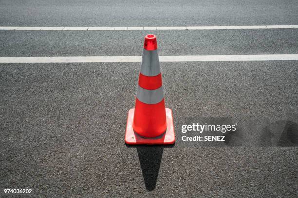traffic cone,an image of cautions on asphalt road - verkehrshütchen stock-fotos und bilder
