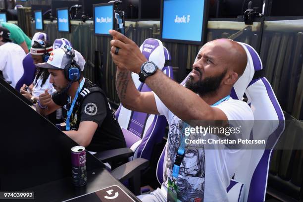 Fighter Demetrious Johnson takes photos before competing in the Epic Games Fortnite E3 Tournament at the Banc of California Stadium on June 12, 2018...