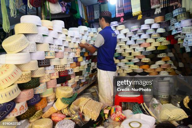 Bangladeshi Muslims buy Islamic cap for prayer ahead of Eid al-Fitr festival, during the holy month of Ramadan in Dhaka, Bangladesh, on June 13,...