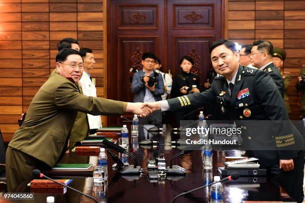 In this handout image provided by South Korean Defense Ministry, South Korean Major. Gen. Kim Do-gyun shakes hands with his North Korean counterpart...