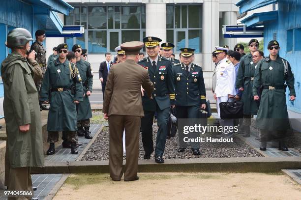 In this handout image provided by South Korean Defense Ministry, South Korean Major Gen. Kim Do-gyun shakes hands with North Korean officer as he...