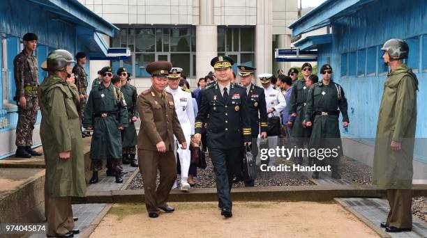 In this handout image provided by South Korean Defense Ministry, South Korean Major Gen. Kim Do-gyun is escorted by a North Korean officer after...