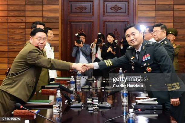 In this handout image provided by South Korean Defense Ministry, South Korean Major. Gen. Kim Do-gyun shakes hands with his North Korean counterpart...