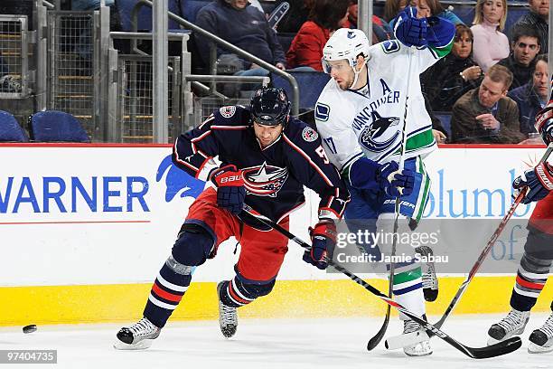 Forward Ryan Kesler of the Vancouver Canucks skates with the puck against defenseman Fedor Tyutin of the Columbus Blue Jackets on March 2, 2010 at...