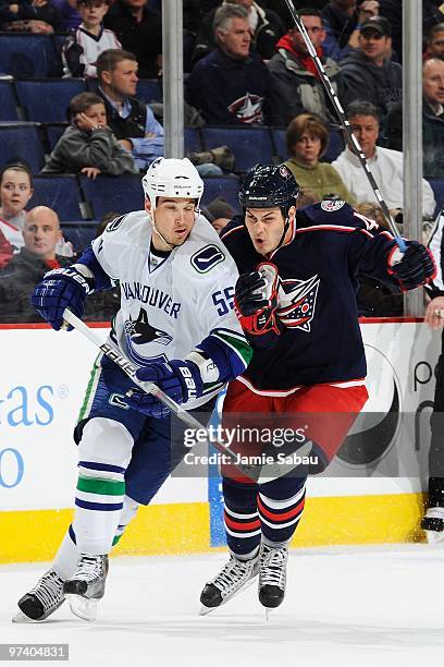 Forward Jared Boll of the Columbus Blue Jackets attempts to skate around the check of defenseman Shane O'Brien of the Vancouver Canucks on March 2,...