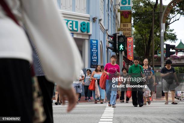 People cross the road in the Chinatown area of Singapore, on Wednesday, June 13, 2018. Tourism as well as the consumer sector will likely see a lift...