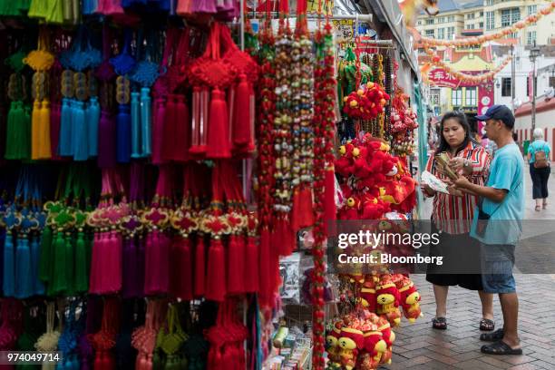 Customers looks at folding fans at a stall in the Chinatown area of Singapore, on Wednesday, June 13, 2018. Tourism as well as the consumer sector...