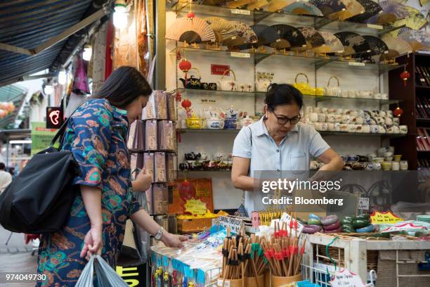 Customers look at chopsticks at a stall in the Chinatown area of Singapore, on Wednesday, June 13, 2018. Tourism as well as the consumer sector will...