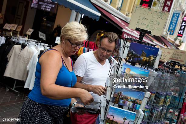 Tourists browse postcards at a stall in the Chinatown area of Singapore, on Wednesday, June 13, 2018. Tourism as well as the consumer sector will...