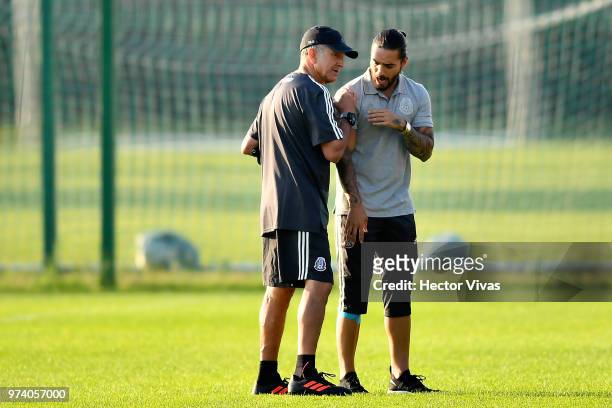 Juan Carlos Osorio, coach of Mexico and singer Maluma talk during a training session at FC Strogino Stadium on June 12, 2018 in Moscow, Russia.