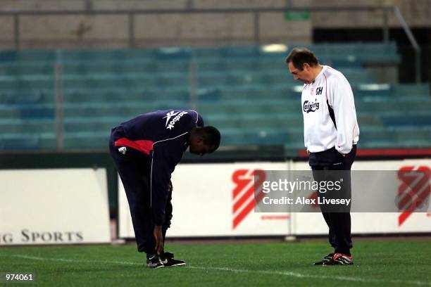 Emile Heskey of Liverpool talks with manager Gerard Houllier about his injury during a training session ahead of the UEFA Cup match between Roma and...
