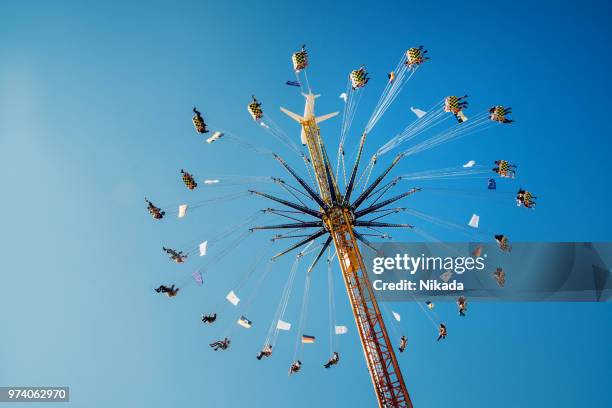 people enjoy the ride on a chairoplane, oktoberfest, munich, germany - the twist stock pictures, royalty-free photos & images