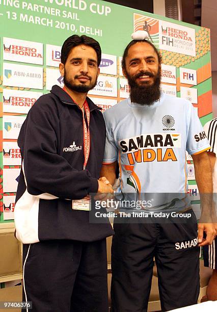India hockey team captain Rajpal Singh and Pakistan hockey team captain Zeeshan Ashraf pose during a press conference in New Delhi on February 26,...