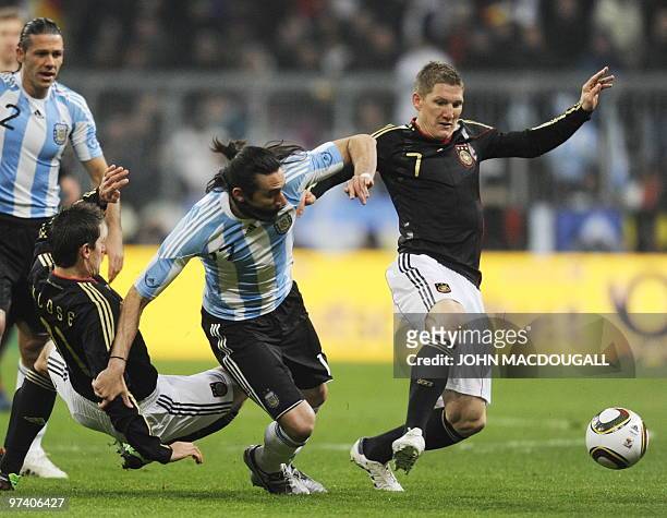 Argentina's midfielder Jonás Gutiérrez vies for the ball with Germany's striker Miroslav Klose and Germany's midfielder Bastian Schweinsteiger during...