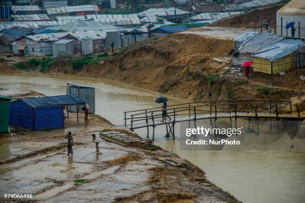 Rohingya is walking on the bridge of a canel inside the kutupalong makeshift shelter in Coxs Bazar, Bangladesh on June 13, 2018.