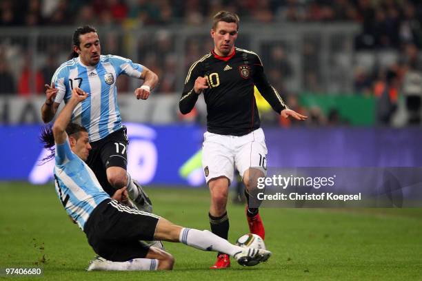 Martin Demichelis of Argentina challenges Lukas Podolski of Germany during the International Friendly match between Germany and Argentina at the...