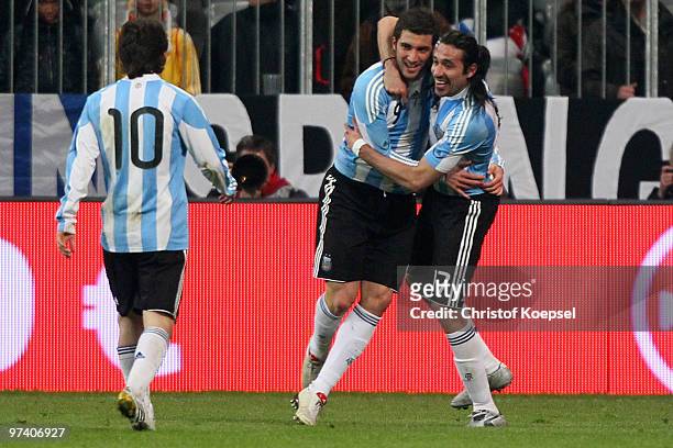 Gonzalo Higuain of Argentina celebrates the first goal with Jonás Gutiérrez of Argentina and Lionel Messi during the International Friendly match...