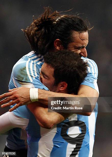 Gonzalo Higuain of Argentina celebrates with teammate Jonas Gutierrez after he scores his team's opening goal during the International Friendly match...