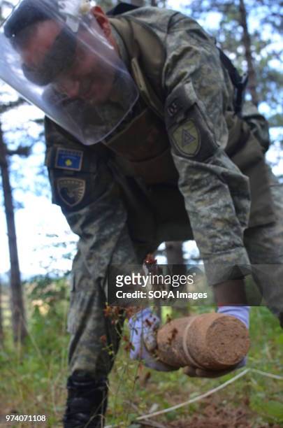 Member of the Kosovo Security Force Emergency Ordinance Disposal team removes an unexploded shell from Freedom Park near Prizren, southern Kosovo....