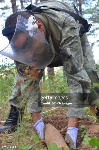 Member of the Kosovo Security Force Emergency Ordinance Disposal team removes an unexploded shell from Freedom Park near Prizren, southern Kosovo....