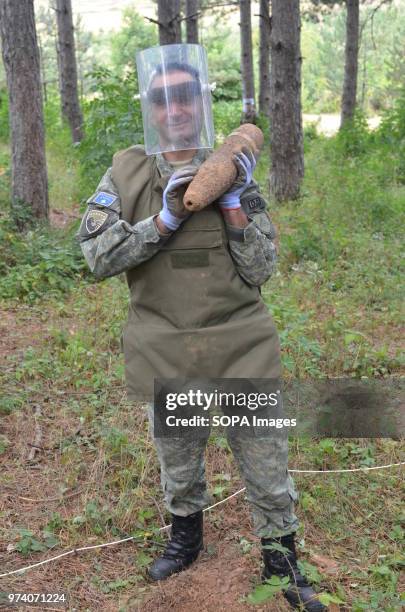 Member of the Kosovo Security Force Emergency Ordinance Disposal team removes an unexploded shell from Freedom Park near Prizren, southern Kosovo....