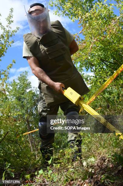 Member of the Kosovo Security Force Emergency Ordinance Disposal team scans for the ground for unexploded shells and mines in Freedom Park near...