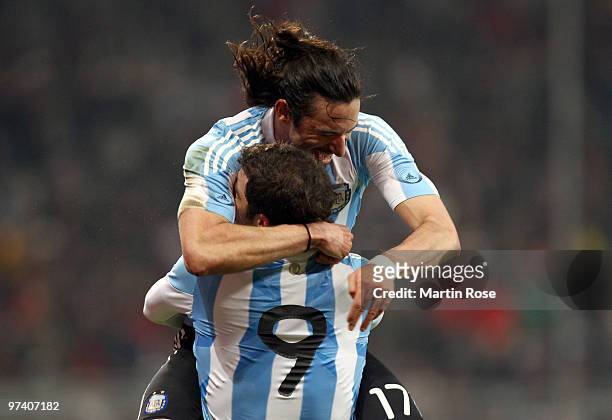 Gonzalo Higuain of Argentina celebrates with team mate Jonas Gutierrez after scoring his team's opening goal during the International Friendly match...