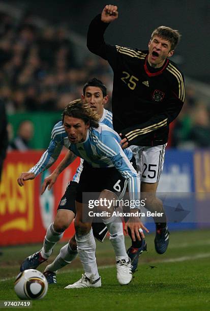 Thomas Mueller of Germany fights for the ball with Gabriel Heinze and Angel Di Maria of Argentina during an international friendly match between...