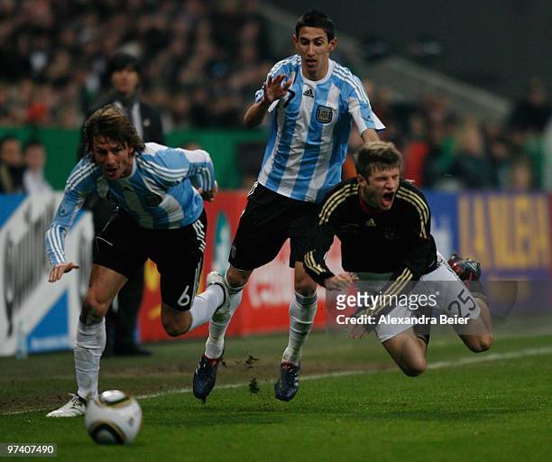 Thomas Mueller of Germany fights for the ball with Gabriel Heinze and Angel Di Maria of Argentina during an international friendly match between...