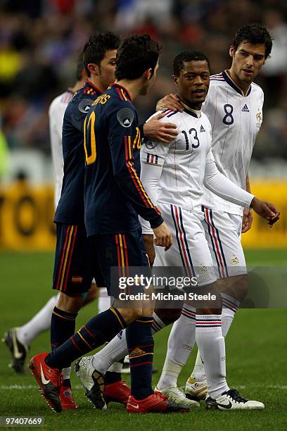 Patrice Evra voices his opinion towards Cesc Fabregas of Spain as team mate Yoann Gourcuff holds him back at the end of the first half during the...