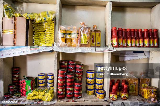 Bottles, cans and packets of general goods are displayed for sale at the fresh-vegetable stall co-owned by Janeffer Wacheke in Nairobi, Kenya, on...