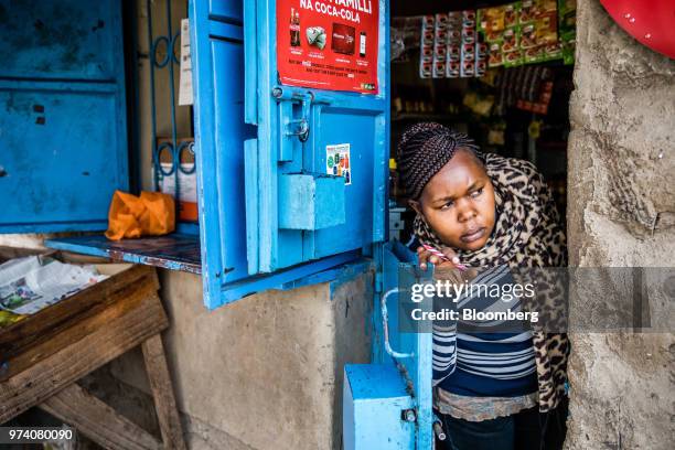 Janeffer Wacheke, co-owner of a fresh-vegetable stall, waits for the arrival of a Twiga Foods Ltd.'s delivery truck at her stall in Nairobi, Kenya,...